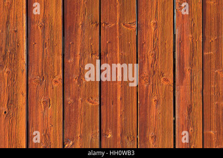 Nahaufnahme auf einer roten Holzwand bei strahlendem Sonnenschein. Dielen, rot lackiert-boards. Stockfoto
