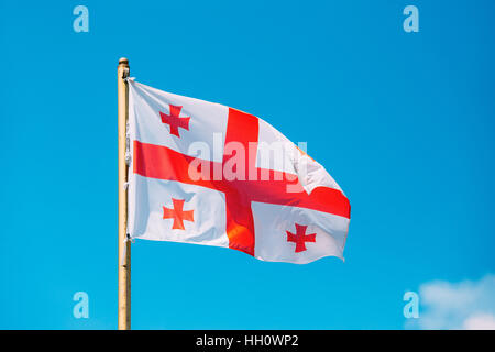 Schließen Sie die Flagge Georgiens, fünf Cross-Fähnchen am Fahnenmast am sonnigen blauen Himmelshintergrund. Die weißen und roten Nationalsymbol, bürgerlichen und staatlichen Ensign Stockfoto