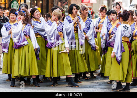 Japan, Kumamoto. Hinokuni Yosakoi Festival. Tänzerinnen und Tänzer stehen, warten zu Beginn der Tanz, in Mauve Yukata und grüne Hosen. Stockfoto