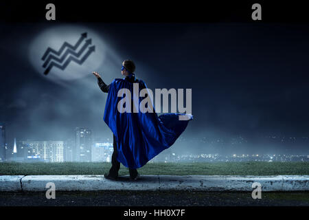 Junger Geschäftsmann in Maske und Umhang Nacht Hintergrund Stockfoto