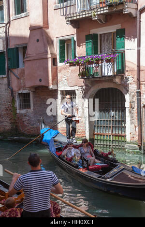High-Angle Shot auf einer Gondel aus dem Blickwinkel einer venezianischen Brücke (Venedig - Italien). Eine typische venezianische Szene. Stockfoto