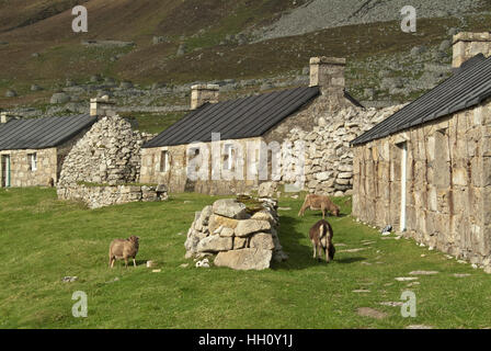 Restaurierten Häuschen und ursprünglichen schwarzen Häuser auf Hirta, Moscow, äußeren Hebriden, Schottland, Vereinigtes Königreich Stockfoto