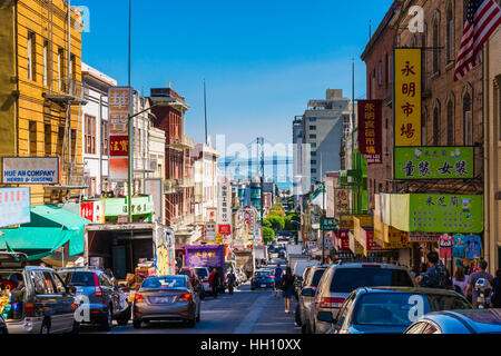 Die Innenstadt von Stadtleben in einer belebten Straße von Chinatown San Francisco. Mit vielen Menschen, Geschäfte und Autos mit Oakland Bay Bridge anzeigen Stockfoto