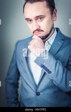 Porträt eines jungen Geschäftsmann auf grauem Hintergrund. Stockfoto