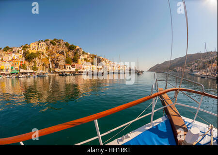 Blick über den Bug eines Bootes als es fährt aus dem Hafen auf Symi, Griechenland Stockfoto