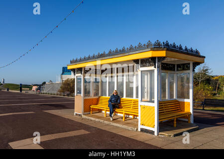 Traditionelle Vintage gelb Tierheim mit hölzernen Sitzbänken auf der Promenade in Southsea, Portsmouth, Hampshire, Südengland Stockfoto