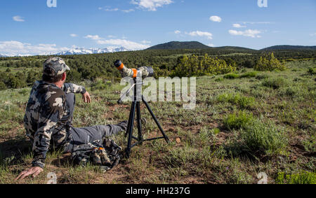 Outdoor-Mann sitzt neben seinem Spektiv Blick auf dem Lande in western Colorado Stockfoto