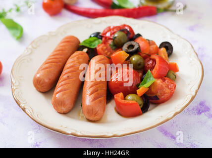 Würstchen gegrillt mit Gemüse im griechischen Stil auf Platte. Stockfoto