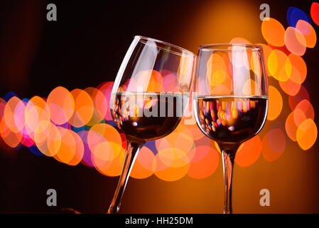 Zwei Weingläser klimpern auf der Party, Hintergrund mit verschwommenen Lichtern Stockfoto