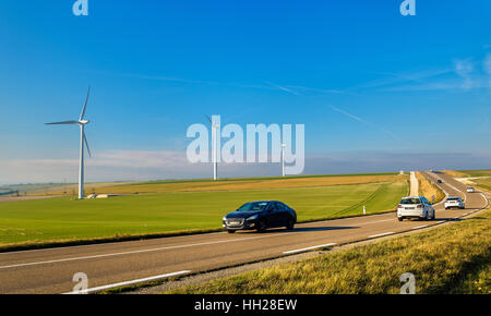 Autos auf einer Autobahn und Windturbinen im Hintergrund - Frankreich Stockfoto