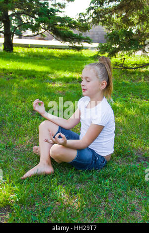 Foto von netten Mädchen in Lotus-pose Stockfoto