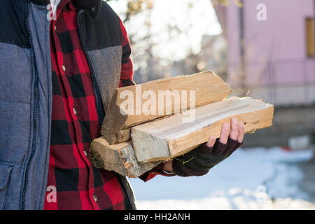 Mann mit Brennholz im Vorgarten Stockfoto