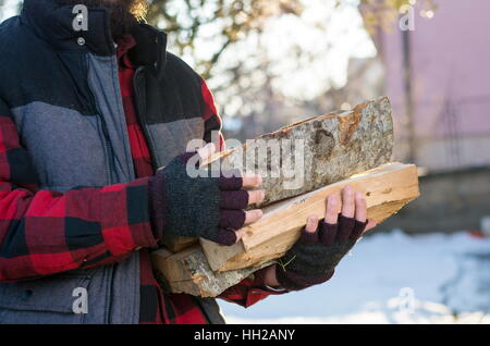 Mann mit Brennholz im Vorgarten Stockfoto