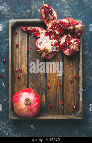 Frische reife Granatäpfel in Holztablett in Stücke geschnitten Stockfoto