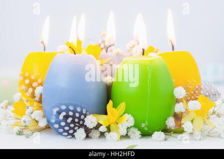 Buntes Osterei Kerzen und Blumen Stockfoto