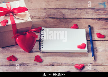 Leere Notebook und Geschenk-Box mit roten Herz auf Holz Hintergrund. Stockfoto