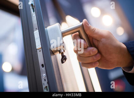 München, Deutschland. 16. Januar 2017. Ein Mann öffnet sich ein Fenster, Fabrikat Hoppe, welche Funktionen spezielle Anti-Eindringling Technologie am Bau 2017 Architektur, Materialien und Systeme-Messe in München, Deutschland, 16. Januar 2017. Foto: Matthias Balk/Dpa/Alamy Live News Stockfoto