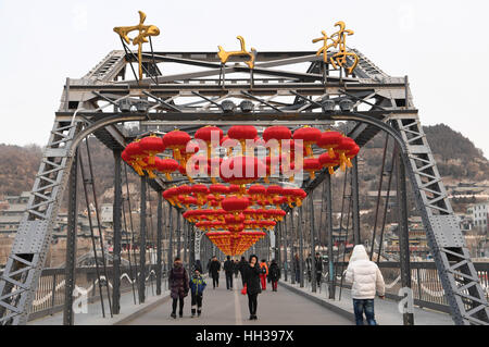 Lanzhou, China Provinz Gansu. 17. Januar 2017. Die Menschen gehen unter roten Laternen auf der Zhongshan-Brücke über den gelben Fluss in Lanzhou, Hauptstadt der Nordwesten Chinas Provinz Gansu, 17. Januar 2017. Mehr als 1.000 Laternen haben aufgestellt auf der Zhongshan-Brücke, das Frühlingsfest oder chinesische traditionelle lunar New Year, die am 28. Januar fällt in diesem Jahr zu begrüßen. Bildnachweis: Fan Peishen/Xinhua/Alamy Live-Nachrichten Stockfoto