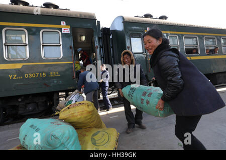 (170117) - CHENGDU, 17. Januar 2017 (Xinhua)--Passagiere entladen Güter des täglichen Bedarfs aus dem 5633 grüne Zug auf dem Sichuan-Teil des Südwest-China Chengdu-Kunming Railway an Wiederverwertung Station, 16. Januar 2017. Da moderne Hochgeschwindigkeitszüge vorbei neue Stationen in ganz China gedreht, durchläuft ein langsamen grüner Zug noch Teilbereichen Armut Daljan Berge, wo die Menschen von Yi ethnische Gruppe hauptsächlich Leben. Altmodische Zug begann 1970 mit keine Klimaanlage und Speisewagen. Jetzt ist es noch eine preiswerte und Convinient Weise für die lokale Bevölkerung zu reisen. (Xinhua/Jiang Ho Stockfoto