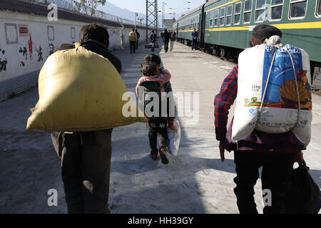 (170117) - CHENGDU, 17. Januar 2017 (Xinhua)--Passagiere tragen Dinge des täglichen Bedarfs 5633 grün auf der Sichuan Teil des südwestlichen China Chengdu-Kunming Railway an der Tiekou Station, 16. Januar 2017 laufen aussteigen. Da moderne Hochgeschwindigkeitszüge vorbei neue Stationen in ganz China gedreht, durchläuft ein langsamen grüner Zug noch Teilbereichen Armut Daljan Berge, wo die Menschen von Yi ethnische Gruppe hauptsächlich Leben. Altmodische Zug begann 1970 mit keine Klimaanlage und Speisewagen. Jetzt ist es noch eine preiswerte und Convinient Weise für die lokale Bevölkerung zu reisen. (Xinhua/J Stockfoto