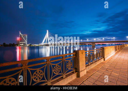 Riga, Lettland. Blick auf berühmte Vansu Schrägseilbrücke In hellen Nachtbeleuchtung von einsamen Ufer der Daugava oder westliche Dwina Und Stockfoto