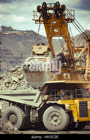 Schwere Muldenkipper und Bagger entwickelt das Eisenerz auf der Tagebau-Website Stockfoto