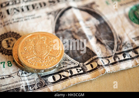 Zwei ein-Pfund-Münzen auf einer US ein-Dollar-Note. Stockfoto