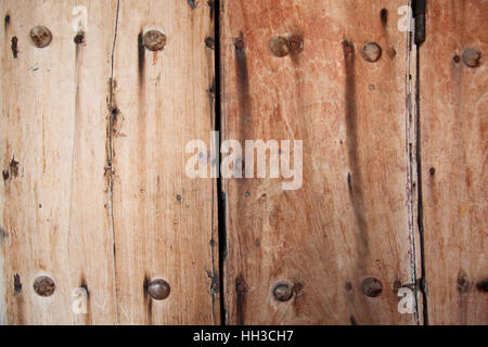 Getragen, verwitterte Holz Tür oder Tor mit starken & sichere Metall Nägel durch es, Cartagena, Kolumbien, Südamerika. Stockfoto