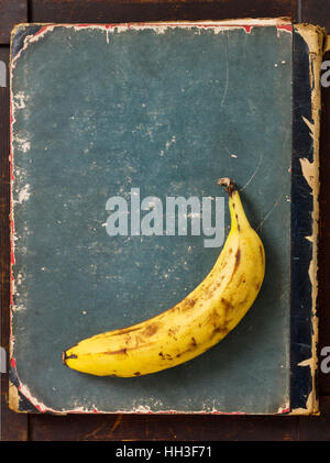 Einzige gefärbten Banane Frucht auf Alter Grunge Buchcover Stockfoto