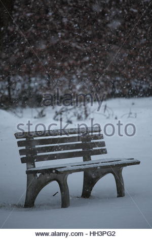 Schnee fällt auf eine Gartenbank in Graden in Bayern, Deutschland während eines harten Winters. Stockfoto