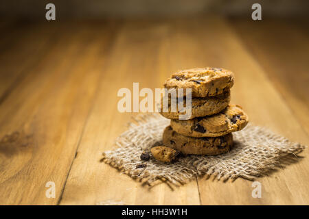 Schokoladen-Plätzchen auf meschotschek Tuch auf Holz. Schokoladenkekse erschossen auf einem braunen Tuch. Stockfoto