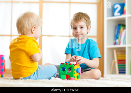 Kinder Jungen spielen mit logischen Lernspielzeug, anordnen und sortieren, Formen und Größen Stockfoto