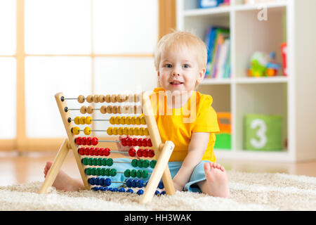 Vorschulkind Baby lernt zählen. Nettes Kind mit Abacus Spielzeug spielen. Kleinen Jungen Spaß drinnen zu Hause, Kindergarten oder Kindertagesstätte. Educatio Stockfoto