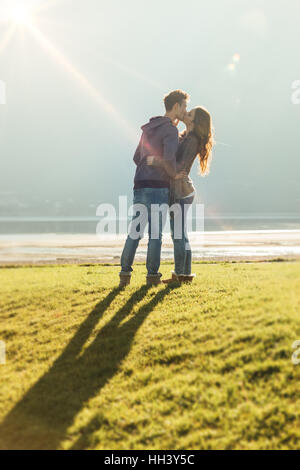 Glücklich Romantisches Liebespaar am See küssen und umarmen in der Sonne, Liebe und Beziehungen-Konzept Stockfoto