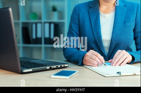 Geschäftsfrau Business Vertrag unterzeichnen am Schreibtisch Stockfoto