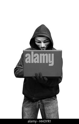 Hacker mit Maske Laptop zu halten, während Eingabe über weißen Hintergrund isoliert Stockfoto