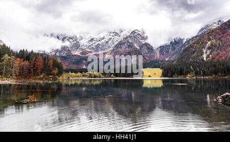 Lago Di Fusine - Mangart See im Herbst oder Winter. Berge mit Schnee, Herbst Farbe Wäldern und Bäumen, ruhig, ruhige See in den Alpen. Landschaft-f Stockfoto