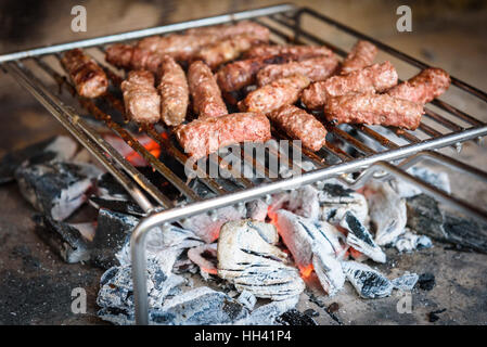 Grillen von Fleisch auf Grill mit Kohle. Cevapcici, Kebab, Landwurst auf Holzkohle Grill BBQ im außen Kamin. Stockfoto