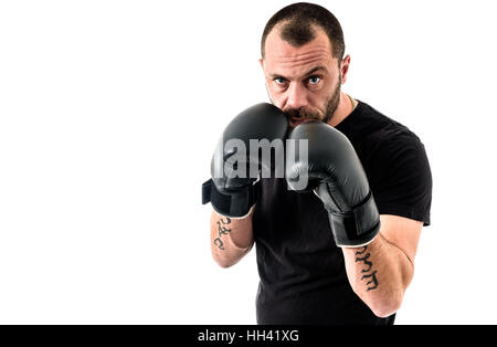 Porträt von männlichen Athleten Boxer Mann aggressiv mit Boxhandschuhen auf schwarzes Hemd und Tätowierungen. Isoliert auf weißem Hintergrund Stockfoto