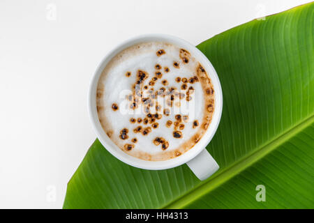 heißen Kaffee Cappuccino-Tasse auf Banane Blatt Whith Beschneidungspfad Stockfoto
