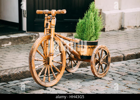 Schöne dekorative Vintage Modell alte hölzerne Rad ausgestattet Fahrradkorb auf Straße Stockfoto