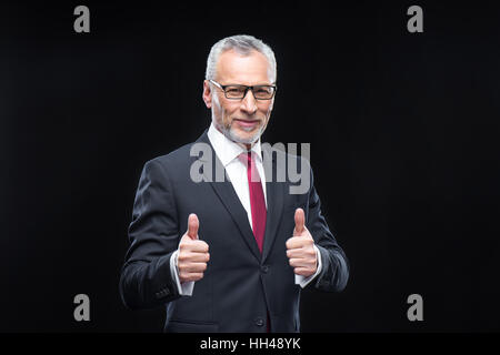 Schöne Reife Geschäftsmann Daumen auftauchen und lächelt in die Kamera Stockfoto