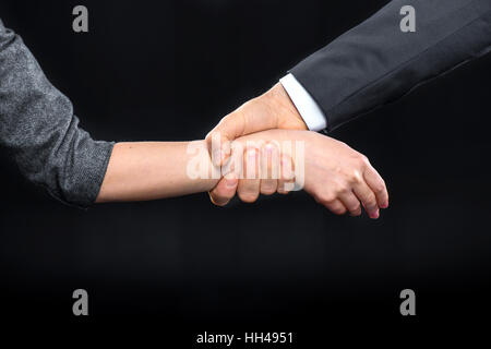 Close-up Teilansicht der Mann packte die Hand der Frau auf schwarz Stockfoto