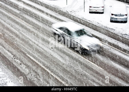 Blurry fahren Autos auf die leere Stadt Straße bei starkem Schneefall Stockfoto