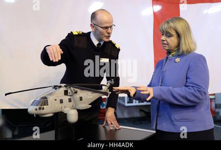 Minister für Verteidigung-Beschaffung Harriett Baldwin (rechts) und Commodore Steve Allen, Royal Navy, stellvertretender Chef des Stabes Aviation, betrachten Sie ein Modell eines Hubschraubers, Merlin mit dem CROWSNEST Airborne Early Warning System ausgestattet, an Bord der HMS Dragon - ein Typ 45 Air Defence Zerstörer - bei Portsmouth Naval Base, wo eine Ankündigung für ein Multi-Millionen-Pfund-Deal für ein neues Überwachungssystem modernste Hubschrauber getragen zum Schutz der Royal Navy-Schiffe, einschließlich der neuen Flugzeugträger der Queen-Elizabeth-Klasse gemacht wurde. Stockfoto