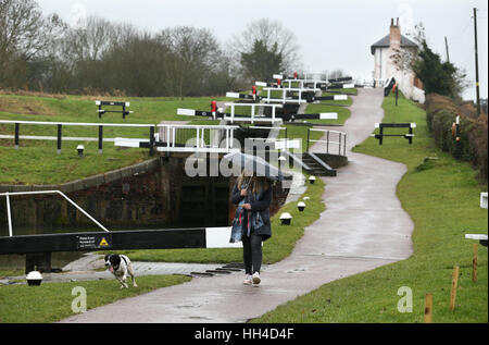 Eine Frau kommt einen Hund entlang der Leinpfad in Foxton sperrt in der Nähe von Market Harborough, Leicestershire. Stockfoto