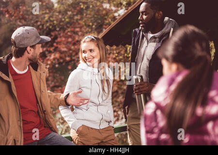 Gruppe von jungen Freunden Reisende ruht in der Nähe von ruhiger Fluss im herbstlichen Wald Stockfoto