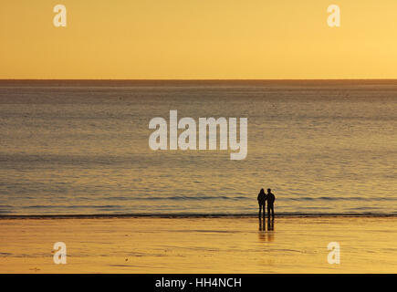 Ein paar am Strand von Puerto Madryn bei Sonnenaufgang, Patagonien, Argentinien Stockfoto