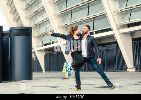 Schöne Roller Skater paar mit Hipster Stil Skaten nach dem Regen. Stockfoto