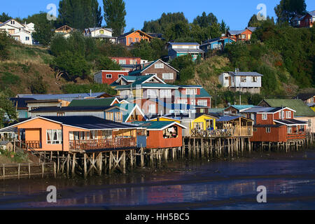 CASTRO, CHILE - 6. Februar 2016: Bunte Palafitos beherbergt traditionellen hölzerne Stelzen an den niedrigen Gezeiten entlang des Rio la Chacra Flusses Stockfoto